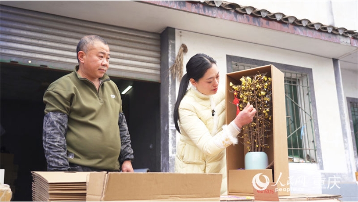 邓纪会正在检查制作完成的蜡梅花束。.png 邓纪会正在检查制作完成的蜡梅花束。.png